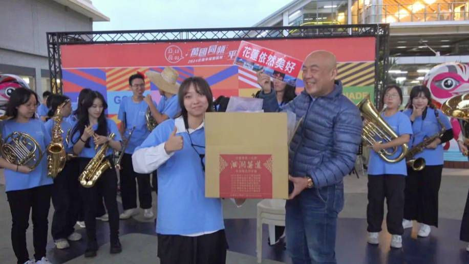 花蓮青年志工中心與東華大學管樂團快閃鼓舞民眾，洄瀾薯道創辦人劉瑞祺（前右）贊助50位成員伴手禮。圖：洄瀾薯道提供